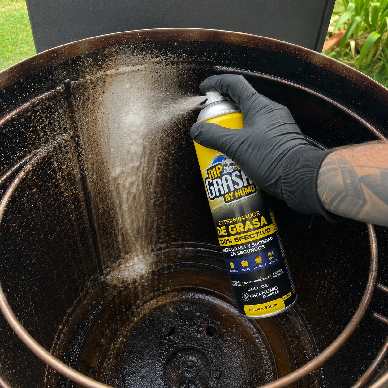 Persona aplicando el desengrasante RIP Grasa en spray sobre la superficie del barril