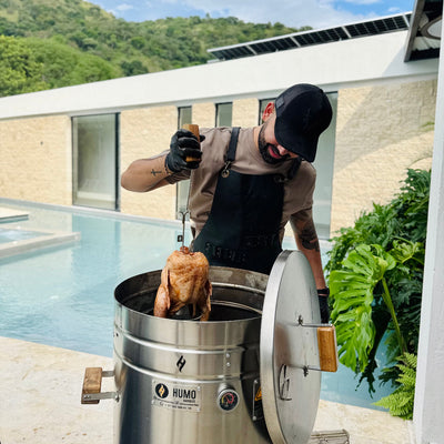 Fotografía Barril asador 60 libras en uso asando un pollo entero