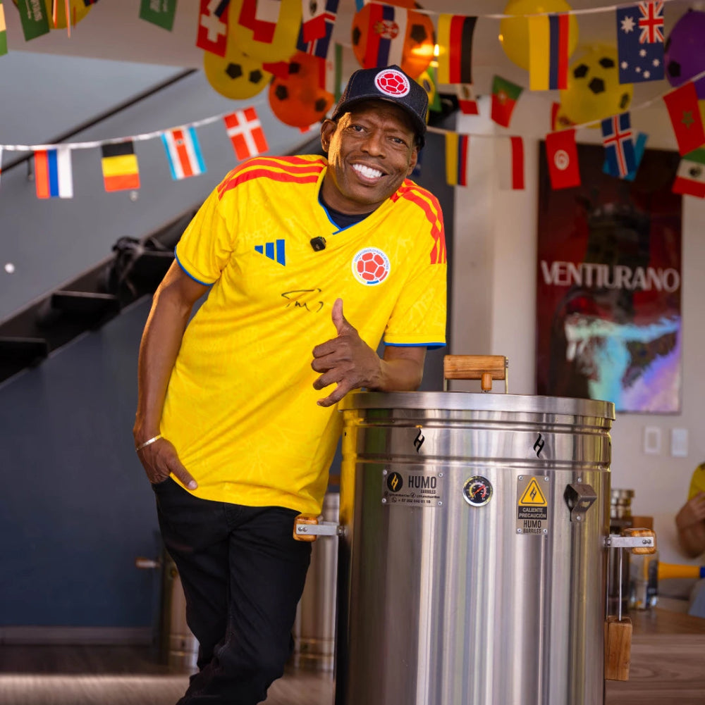 Tino Asprilla con camiseta de la selección Colombia junto al barril ahumador Humo Barriles de 60 libras